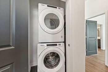 A white front load washer and dryer in a laundry room.  at The Sophia, Venice, FL, 34275